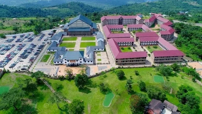 Aerial view of the Anagkazo campus in the green Akuapem hills, with red-roofed halls, lawns and an auditorium